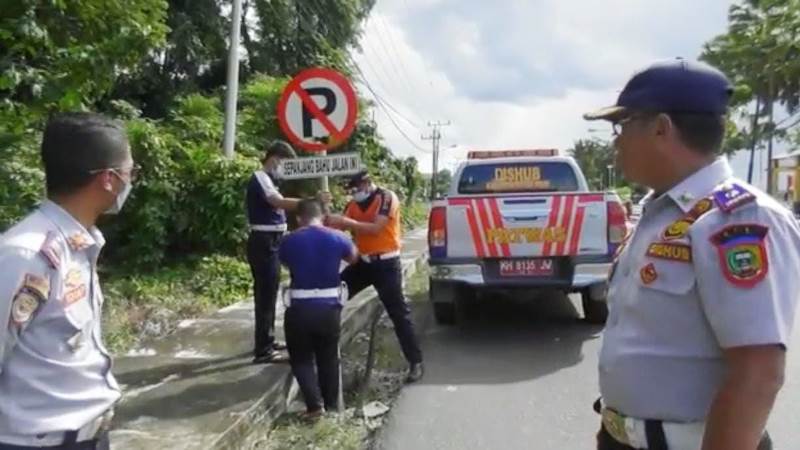 Petugas Dishub Kabupaten Pulang Pisau memasang rambu larangan parkir di Jalan Tingang Menteng depan taman sumbu kurung.