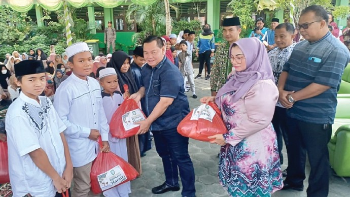 Bupati Kotim H Halikinnor didampingi Wabup, Irawati saat menyerahkan bantuan kepada salah seorang murid SDN 2 MB Hulu dalam acara Ramadan Berbagi, Jumat (14/4).(FOTO : BAHRI/KP)