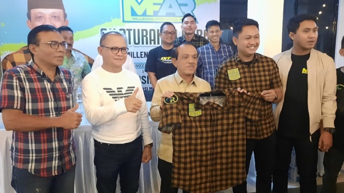 Abdul Razak (menerima) baju MFAR didampingi Dewan Pembina Tingkat Nasional MFAR Mukhtarudin, di salah satu kafe di Jalan Kinibalu, Sabtu (10/6).(FOTO : HAFIDZ/PROKALTENG.CO)