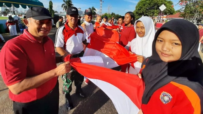 Sekda Seruyan, Djainuddin Noor. Mewakili Bupati bersama Unsur Forkompinda, Asisten dan kepala OPD, menyerahkan bendera merah putih di Depan Stadion Mini Gagah Lurus Kuala Pembuang, Minggu (30/7). (FOTO : PROKOM SERUYAN).