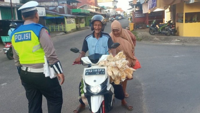 Anggota Satlantas Polres Seruyan memberikan imbauan kepada pengendara sepeda motor berboncengan, yang tidak menggunakan helm di jalan raya Kota Kuala Pembuang, Selasa (11/7). (FOTO : POLRES SERUYAN).