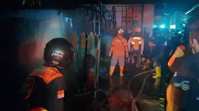 Pemadam kebakaran tengah berusaha memadamkan api di Jalan Temanggung Tilung 13, Kelurahan Menteng Kecamatan Jekan Raya, Selasa malam (8/8).(HAFIDZ/PROKALTENG.CO)