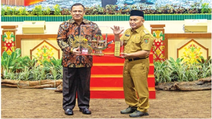 Gubernur Kalteng H Sugianto Sabran memberikan cendera mata kepada Ketua KPK Firli Bahuri saat rakor di Aula Jayang Tingang, Kamis (7/9). Dalam rapat tersebut, gubernur menyentil kewajiban PBS membangun kebun plasma. (FOTO : ARIEF/KP)