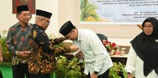 Pengalungan tanda peserta oleh Kepala Kantor Wilayah Kementerian Agama Kalteng, H Noor Fahmi di Aula Arafah Asrama Haji Al-Mabrur, Minggu (9/2/2025). (MMC KALTENG)