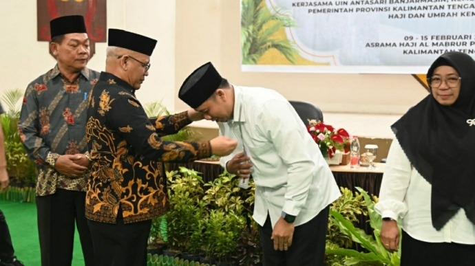 Pengalungan tanda peserta oleh Kepala Kantor Wilayah Kementerian Agama Kalteng, H Noor Fahmi di Aula Arafah Asrama Haji Al-Mabrur, Minggu (9/2/2025). (MMC KALTENG)