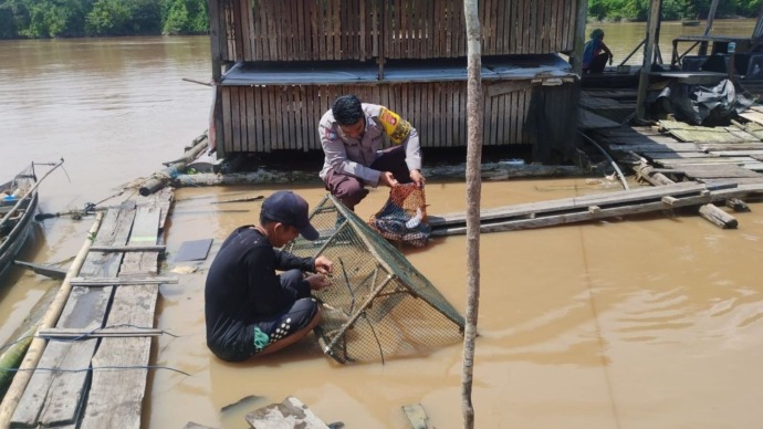 Personel Polsek Sabangau saat menghampiri pemilik keramba ikan di Kecamatan Sabangau, Kota Palangka Raya pada Kamis (27/2). (Humas Polresta)