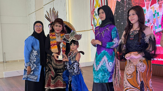 Kepala Dinas Pariwisata, Kebudayaan, Kepemudaan dan Olahraga, Apollonia saat menyerahkan lomba Fashion Show Pesta Etnik 2025, Minggu (9/2/2025). (Mutia/Prokalteng.co)