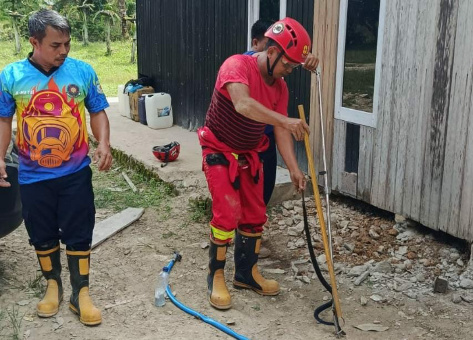 Petugas Pemadam Kebakaran Lamandau saat melakukan evakuasi ular Cobra di rumah warga. (FOTO: ISTIMEWA)