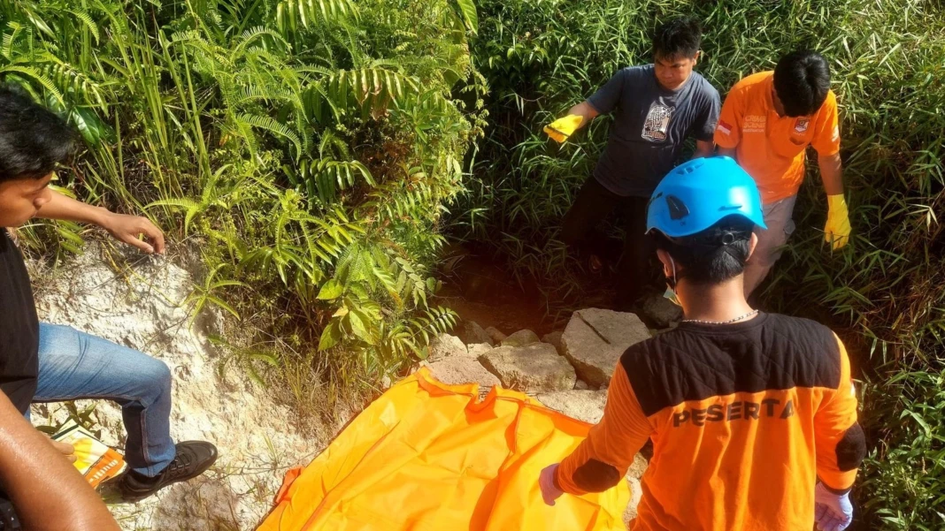 Petugas kepolisian mengevakuasi jasad perempuan tanpa identitas di parit Jalan Mas Kaya Pangaruh, Gang Bhakti II, Kecamatan Bulik, Kabupaten Lamandau, Kalimantan Tengah, Minggu (25/1/2025). (FOTO: BIB/PROKALTENG.CO)