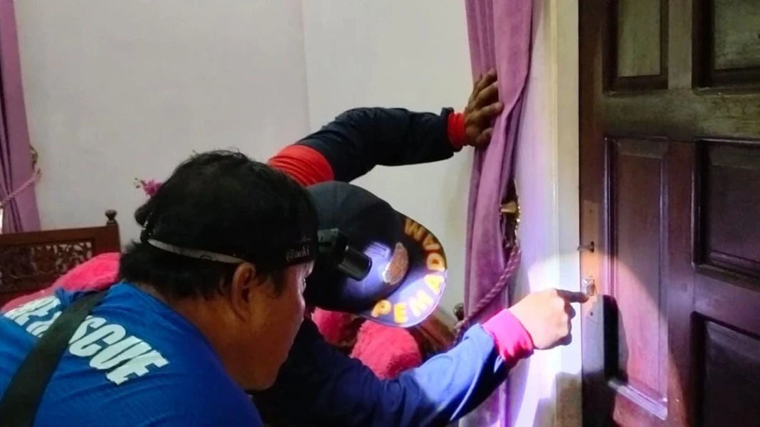 Petugas saat mengevakuasi warga terkunci di dalam kamar rumahnya Jalan Menteng, Kota Palangka Raya pada Sabtu (14/2). (DPKP)