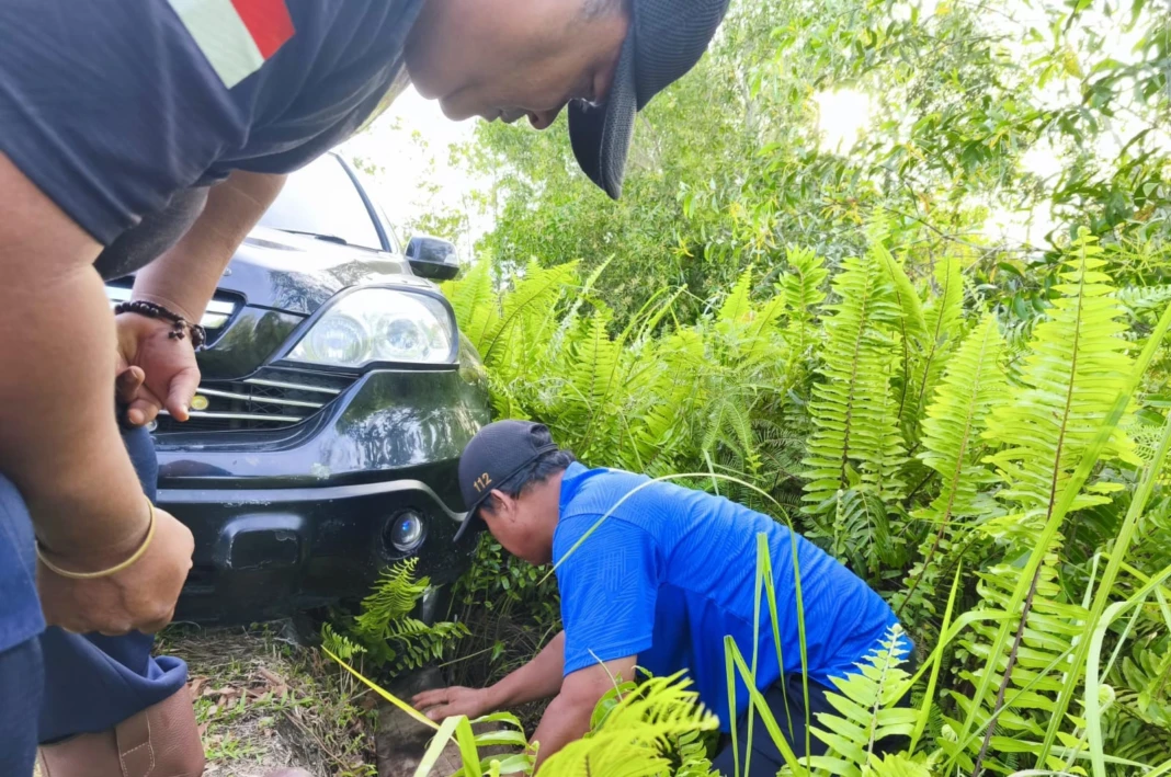 Petugas saat mengevakuasi mobil terperosok di sisi Jalan Adonis Samad, tepat di tepi siring, Sabtu (14/2). (DPKP)