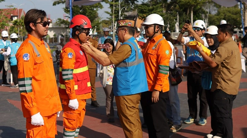 Simbolis pemasangan APD kepada salah satu anggota Tim PDKB yang akan bekerja oleh Pelaksana Tugas Sekretaris Daerah Provinsi Kalteng, Ir. Leonard S. Ampung, M.M., M.T.